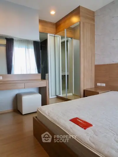 Modern bedroom with wooden accents and mirrored wardrobe in stylish apartment.