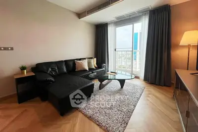 Modern living room with sleek black sofa, stylish coffee table, and city view from large window.