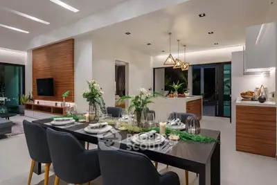Luxurious open-plan living and dining area with modern decor and elegant lighting.