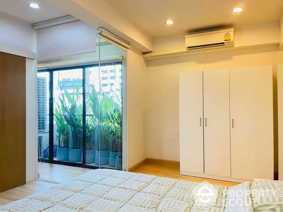 Modern bedroom with balcony access and air conditioning in urban apartment