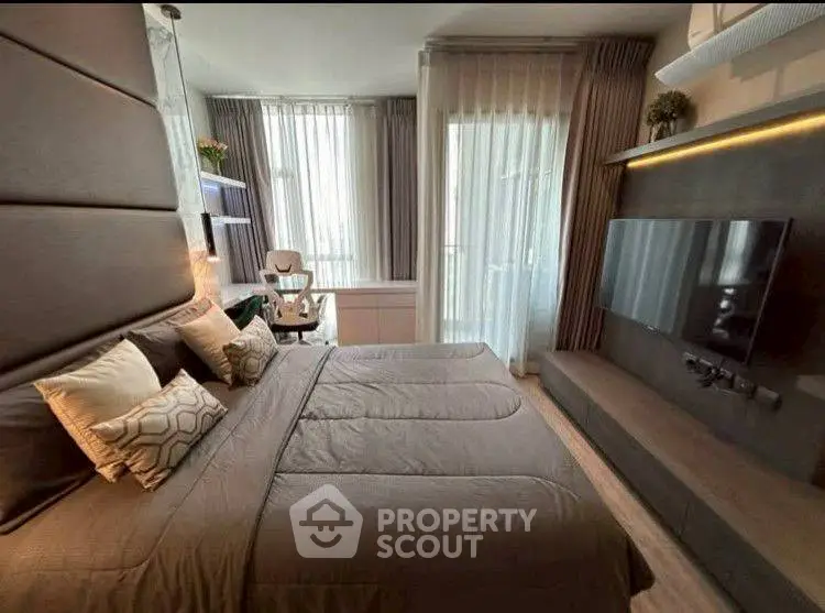 Modern bedroom with stylish decor and large TV, perfect for relaxation.