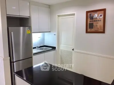 Modern kitchen with sleek cabinetry and stainless steel appliances in a compact layout.