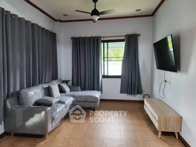 Modern living room with sleek furniture and wall-mounted TV, perfect for relaxation and entertainment.