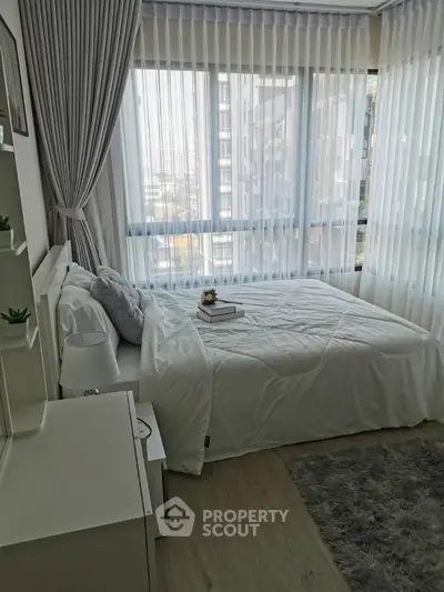 Bright and cozy bedroom with large windows and modern decor in a high-rise apartment.
