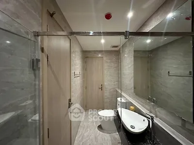 Modern bathroom with sleek design, featuring a glass shower and stylish fixtures.