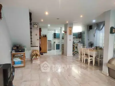 Spacious open-plan living and dining area with modern kitchen in a bright, airy home.