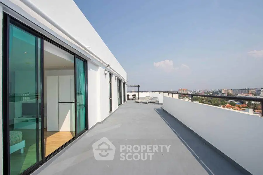Spacious rooftop terrace with panoramic city views and modern glass doors.
