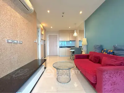 Modern living room with vibrant red sofa and open kitchen layout
