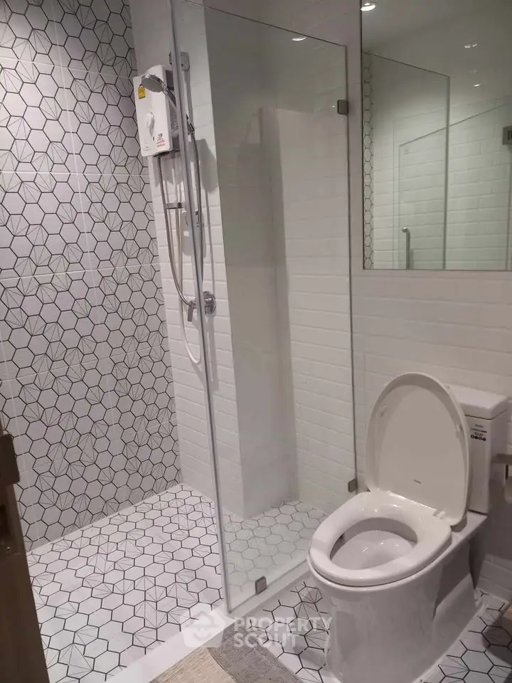 Modern bathroom with geometric tiles and glass shower enclosure