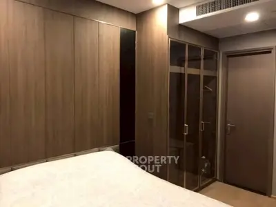 Modern bedroom with sleek wooden wardrobe and cozy bed in a stylish apartment.