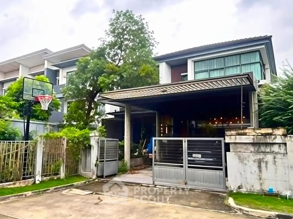 Modern two-story house with a basketball hoop and spacious driveway in a suburban neighborhood.