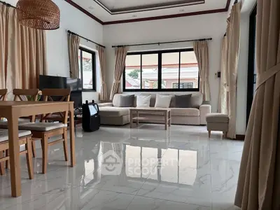 Spacious living room with elegant decor and large windows offering natural light.