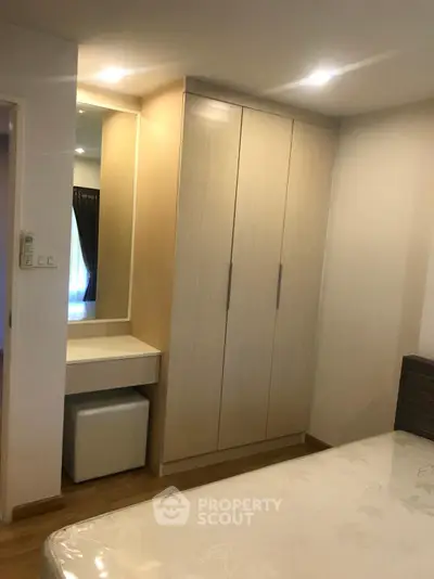 Cozy bedroom with built-in wardrobe and dressing table, perfect for modern living.