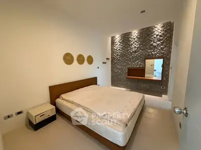 Modern bedroom with stone accent wall and minimalist decor