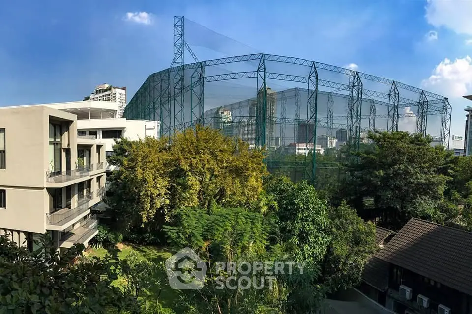 Panoramic view of modern building with lush greenery and cityscape backdrop