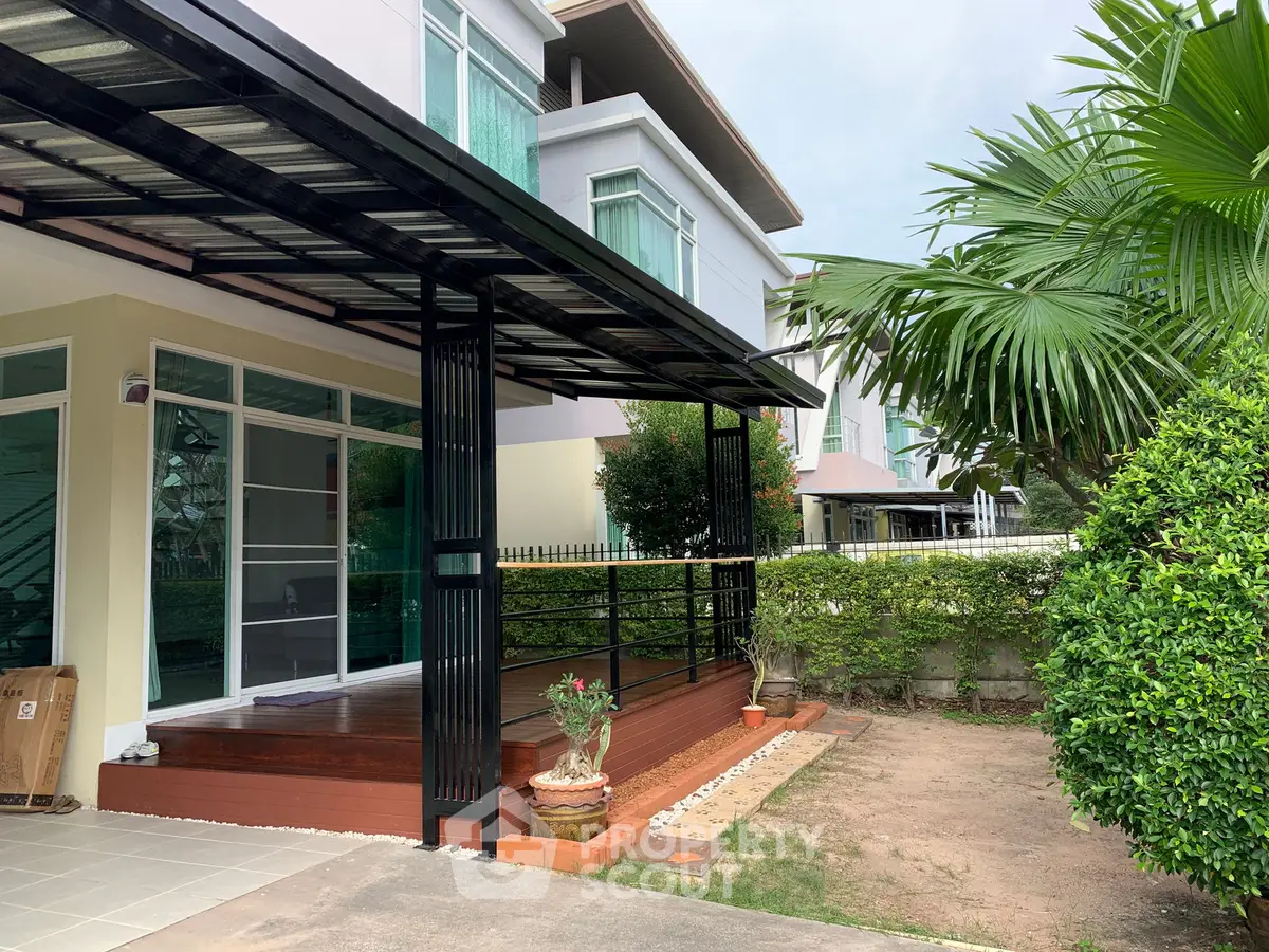 Charming modern home exterior with lush greenery and spacious patio area.