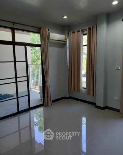 Spacious empty room with large windows and balcony access, ideal for customization.