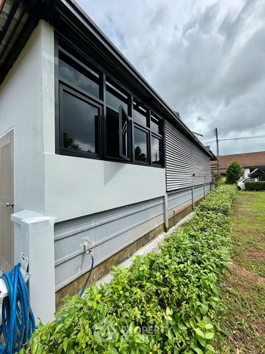 Charming single-story home with lush garden and modern windows, perfect for serene living.