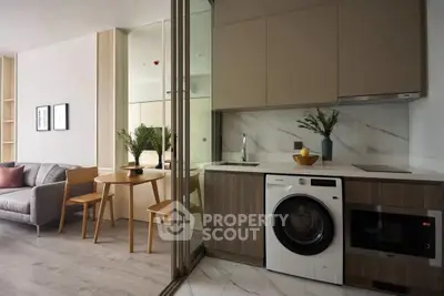 Modern open-plan kitchen and living area with sleek appliances and stylish decor.
