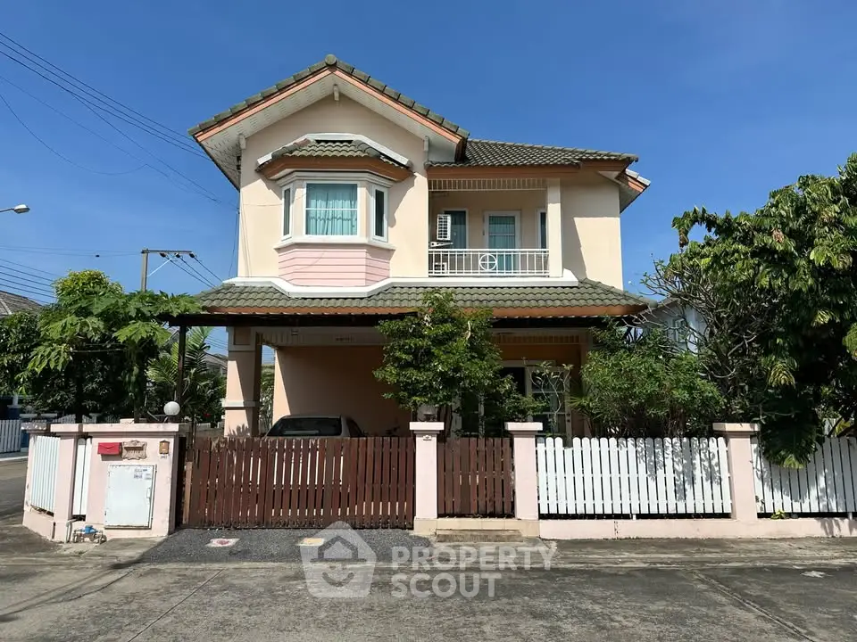 Charming two-story house with a fenced yard and lush greenery, perfect for family living.