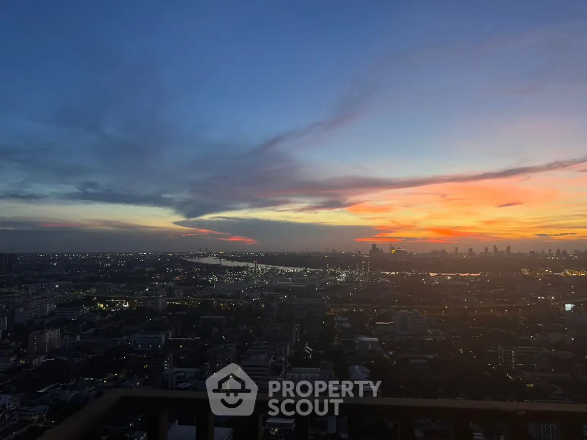 Stunning cityscape view from a high-rise balcony at sunset, showcasing vibrant skies and urban landscape.