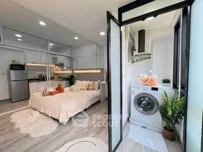 Modern studio apartment with cozy bedroom and in-unit washing machine, featuring sleek design and natural light.