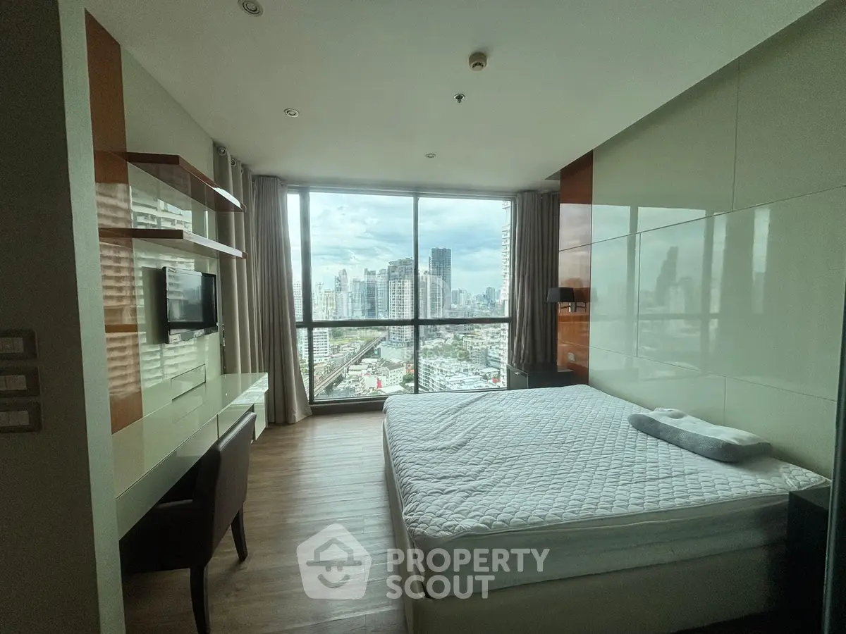 Modern bedroom with city view, featuring sleek design and large windows for natural light.