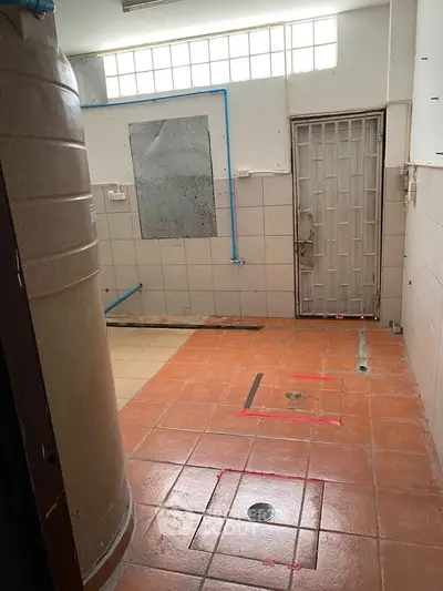 Spacious utility area with tiled flooring and water tank, ideal for storage or laundry setup.