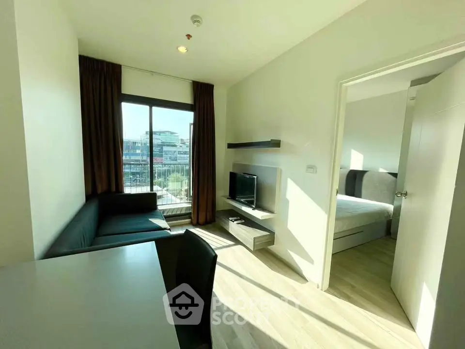Modern apartment living room with natural light and view of adjacent bedroom
