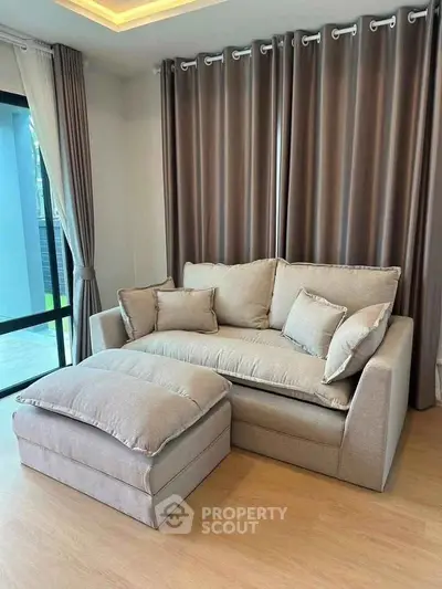 Cozy living room with elegant beige sofa and matching curtains, perfect for relaxation.
