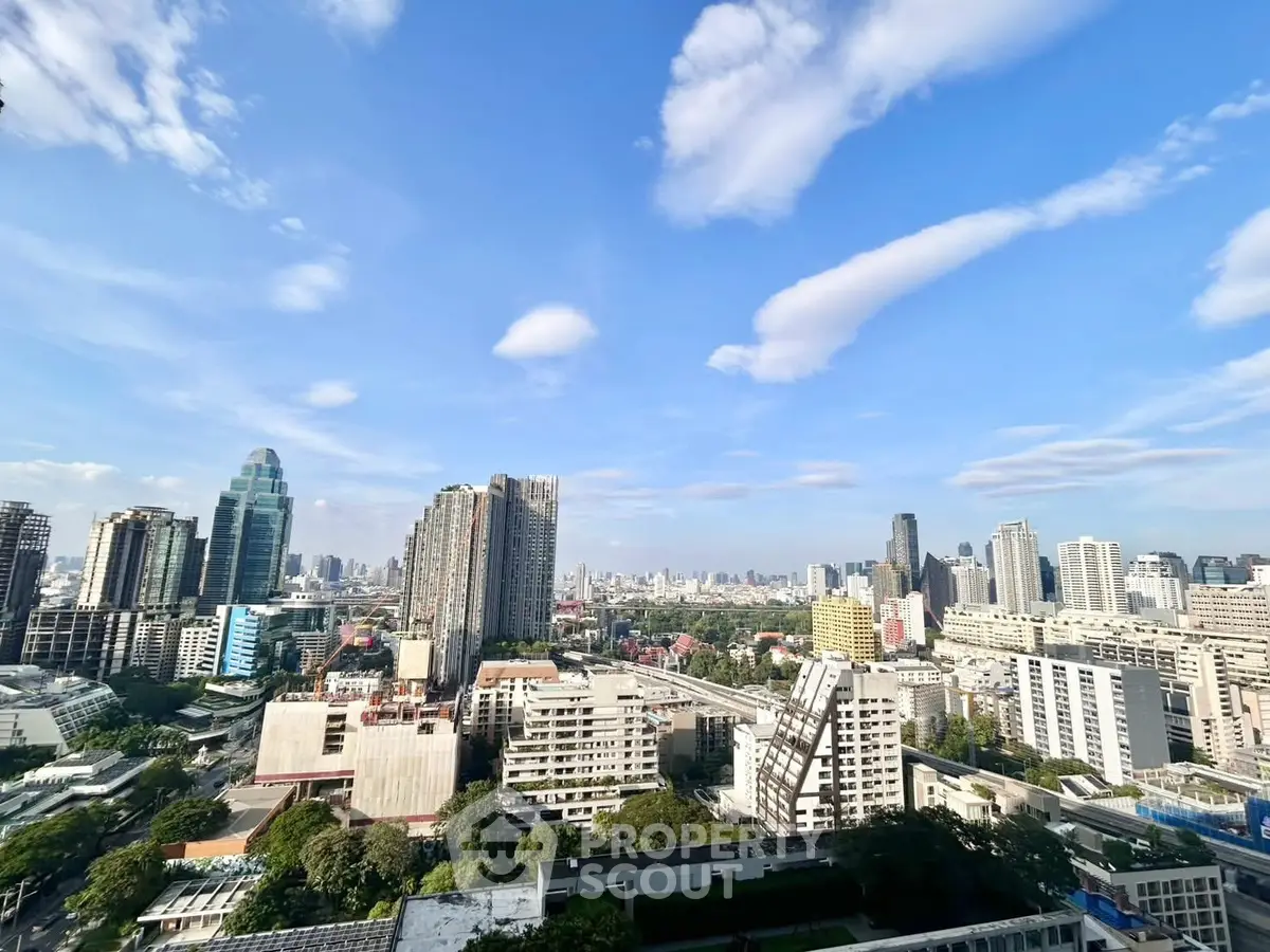 Stunning cityscape view from a high-rise building showcasing urban skyline and blue sky.