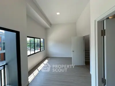 Spacious modern room with large windows and sleek flooring, perfect for versatile living space.