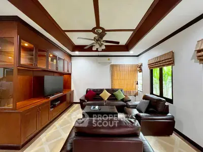 Luxurious living room with leather sofas and wooden cabinetry, perfect for relaxation and entertainment.