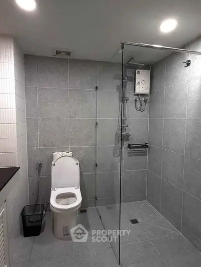 Modern bathroom with glass shower and sleek gray tiles