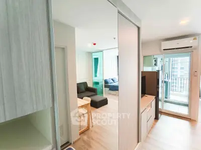 Modern apartment interior with open layout, featuring living room and balcony access.