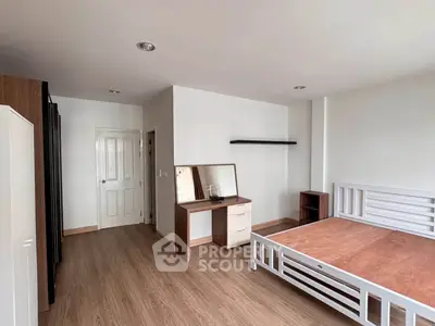 Spacious bedroom with modern wooden flooring and sleek furniture design