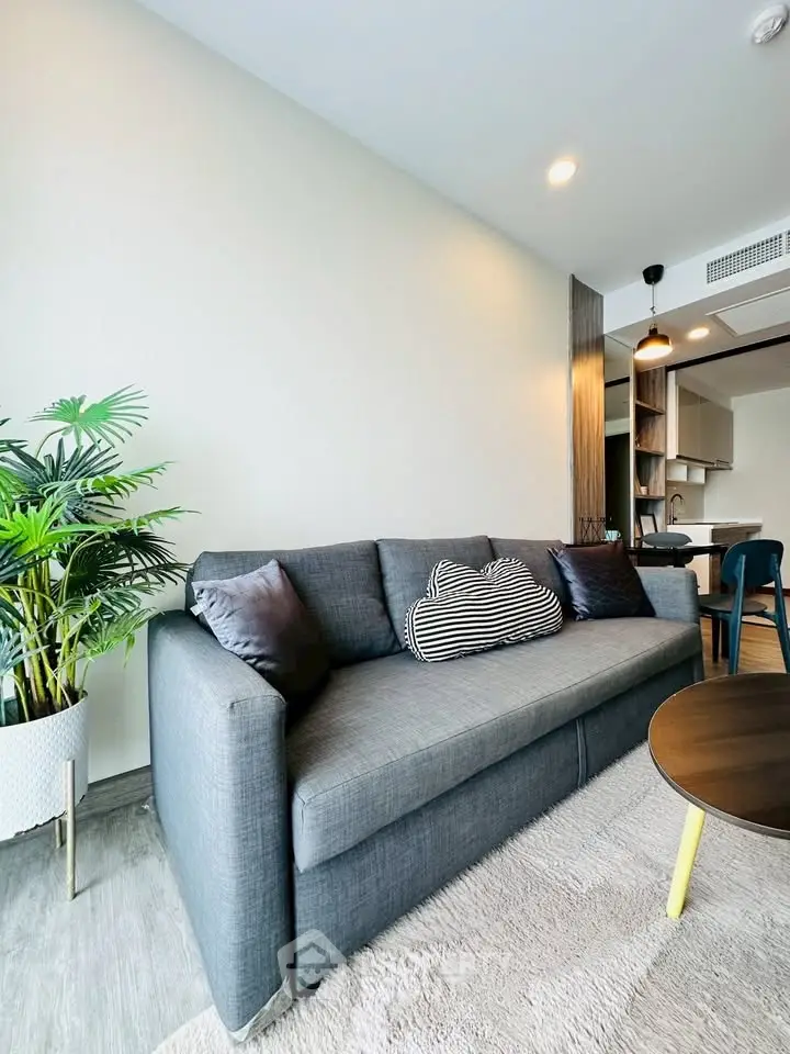 Modern living room with stylish gray sofa and open kitchen layout