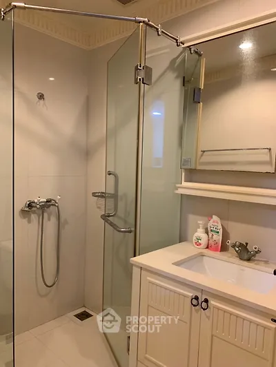 Modern bathroom with glass shower and elegant vanity in a stylish home.