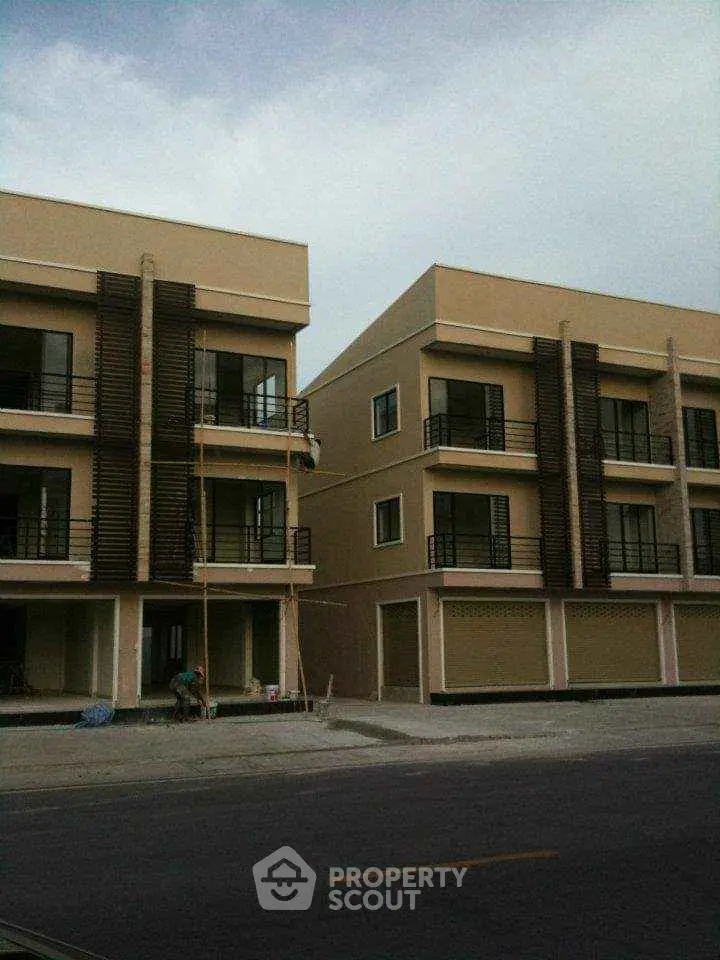 Modern townhouse exterior with multiple balconies and large windows, ideal for urban living.