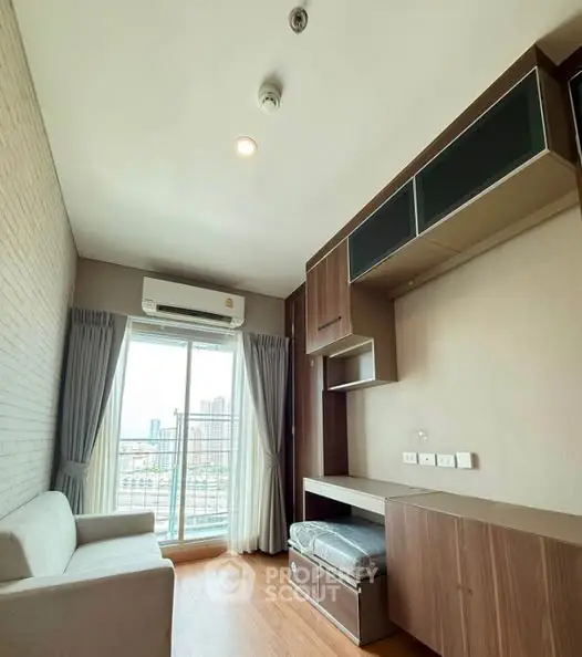 Modern living room with city view, featuring sleek furniture and ample natural light.