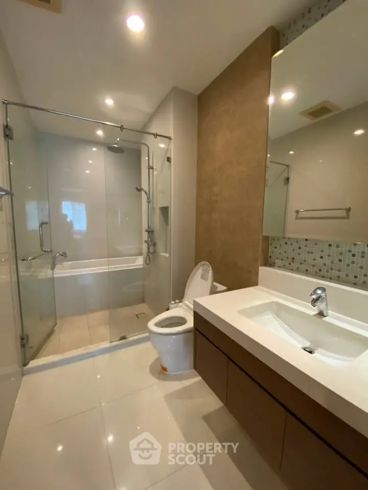 Modern bathroom with glass shower and sleek fixtures in a contemporary home.