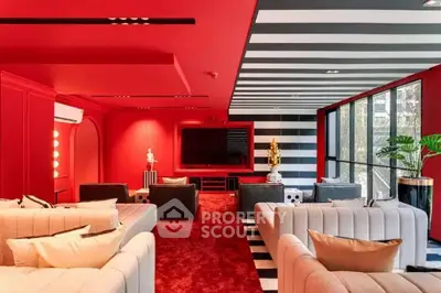 Luxurious modern living room with bold red and black design, featuring plush seating and large windows.