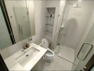 Modern bathroom with glass shower and sleek fixtures in a contemporary apartment.