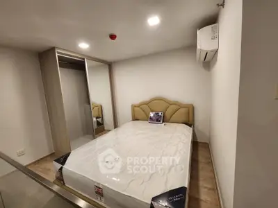 Cozy bedroom with modern design featuring a comfortable bed and mirrored wardrobe.