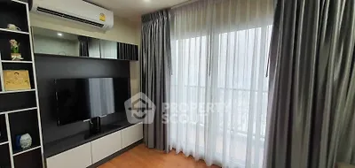 Modern living room with sleek TV setup and large window with curtains