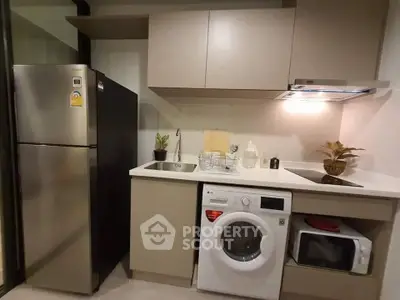 Modern compact kitchen with appliances including fridge, washing machine, and microwave.