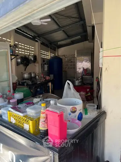 Compact kitchen space with open layout and various cooking utensils.