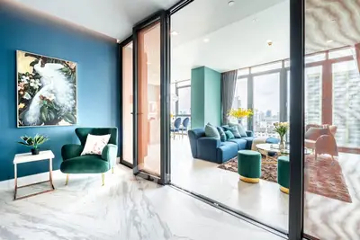 Luxurious modern living room with elegant decor and city view, featuring marble flooring and stylish furniture.