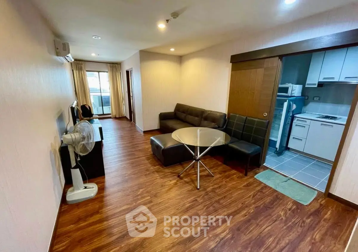 Spacious living room with modern furniture and open kitchen layout in a stylish apartment.