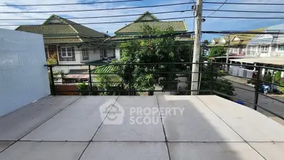 Spacious balcony with neighborhood view and clear blue sky.